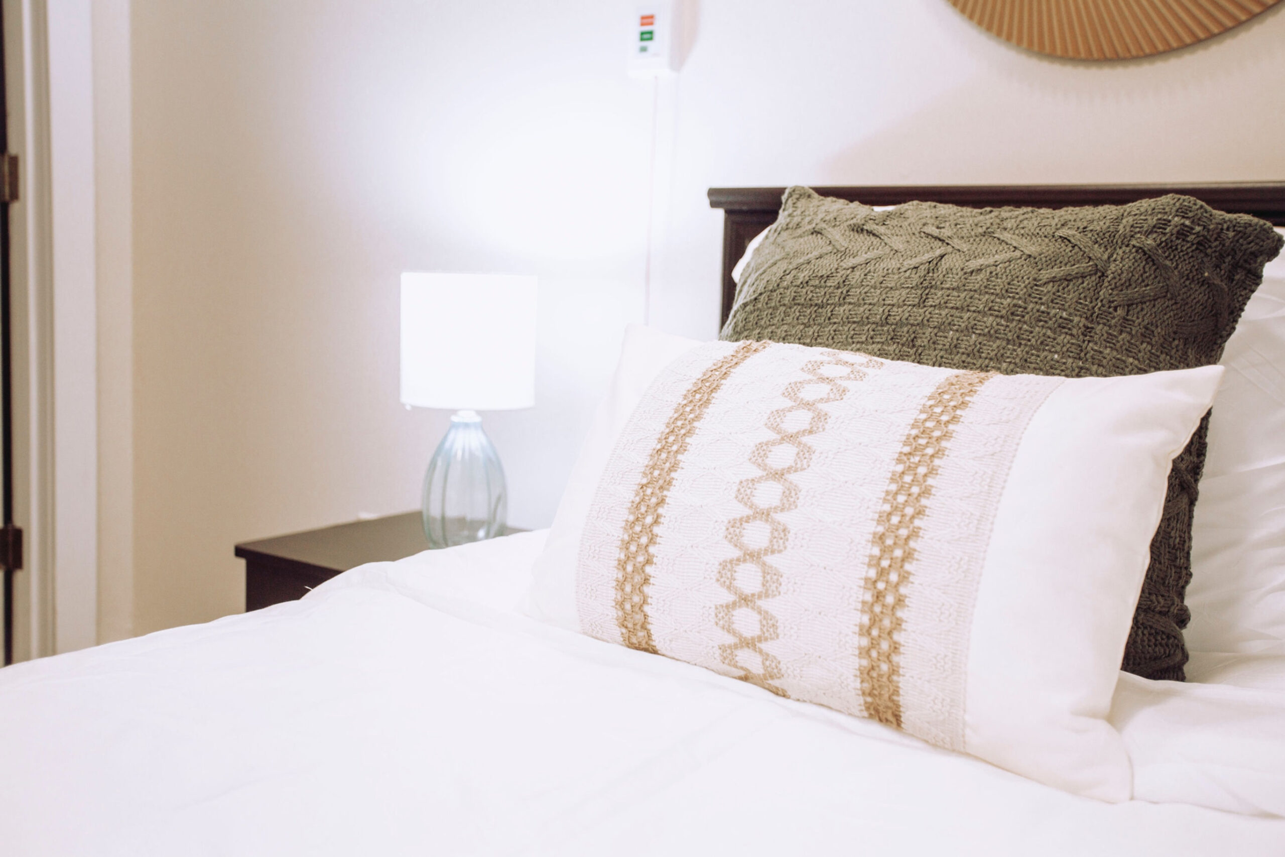 A well-decorated bedroom with cozy bedding and lamp