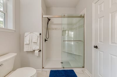 A clean bathroom with a glass shower and towels