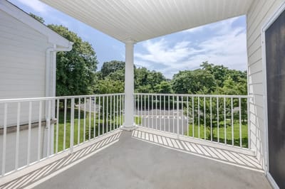 A private balcony with a view of greenery