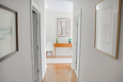 Interior hallway leading to a common area with art