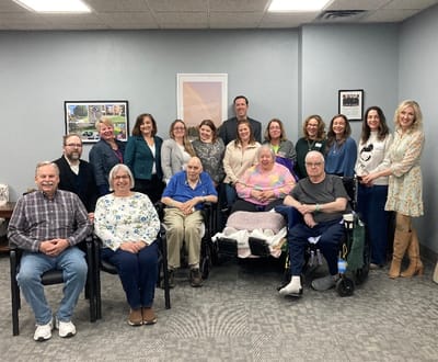 Group photo of residents and staff in a common area