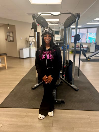 A staff member posing in a fitness area