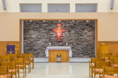 Interior view of a chapel with wooden chairs and altar