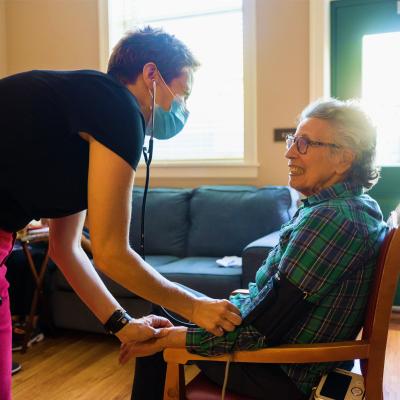 Healthcare worker taking a resident's blood pressure