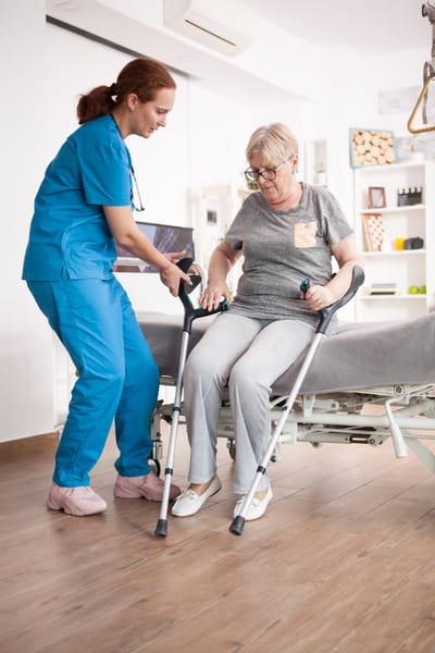 Healthcare worker assisting a senior resident in a room