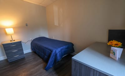 Private resident room with bed and lamp