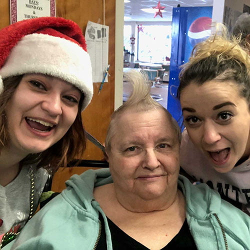 Residents and staff smiling together during a festive event