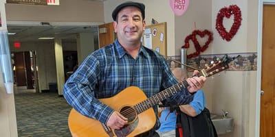A resident enjoying music in the common area