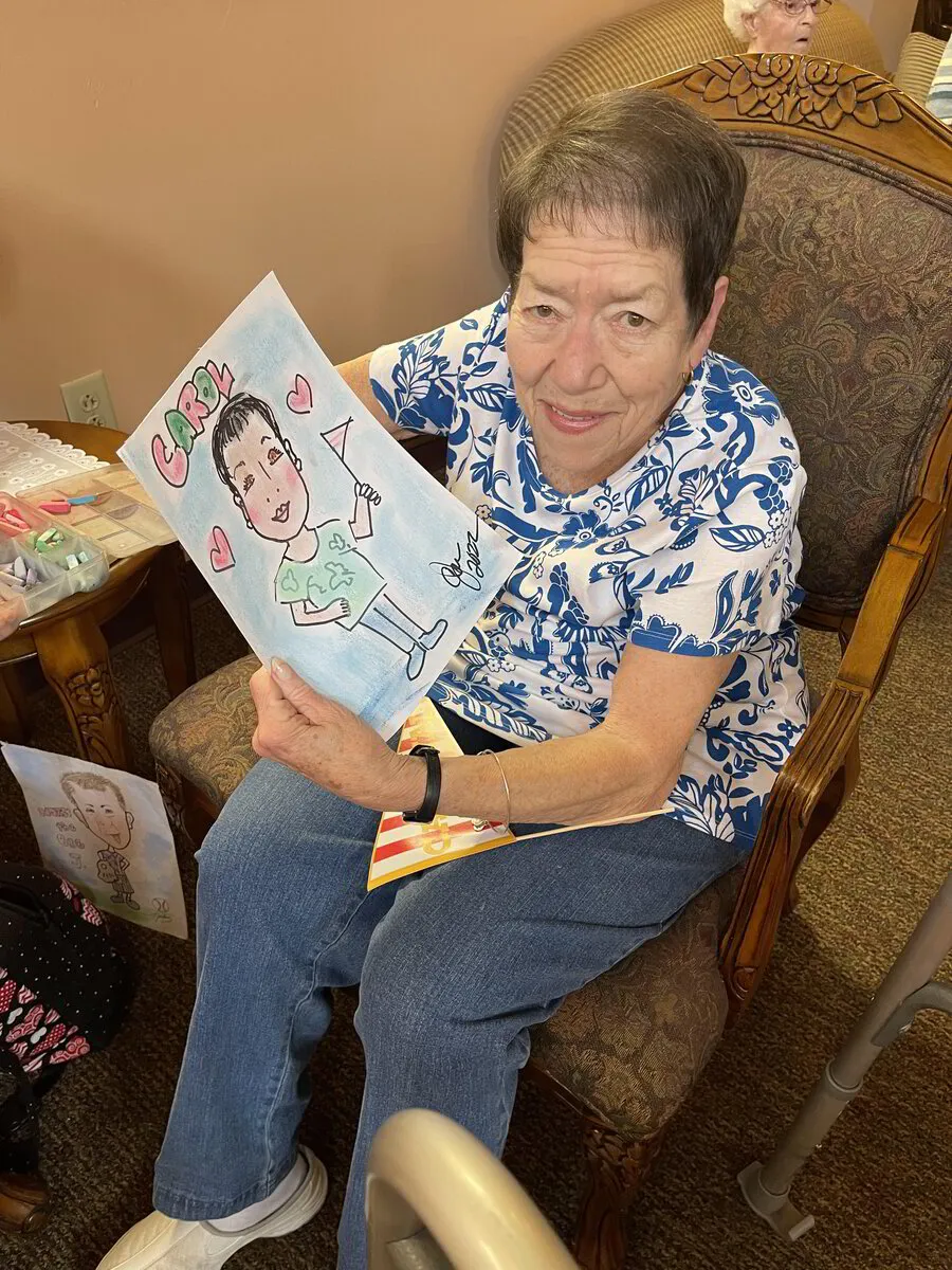 Resident holding a colorful drawing of herself
