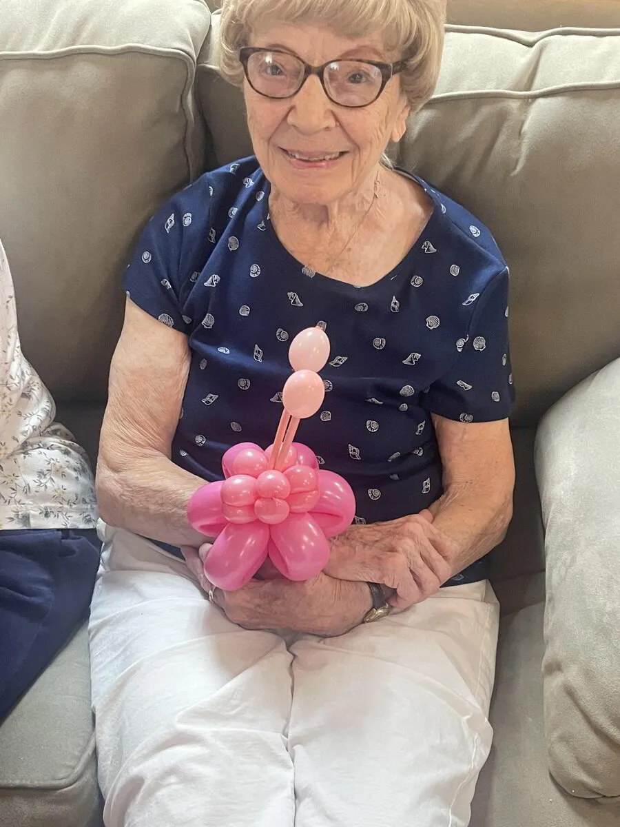 Resident holding a balloon flower decoration