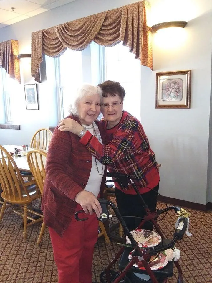 Two residents smiling in a dining room setting