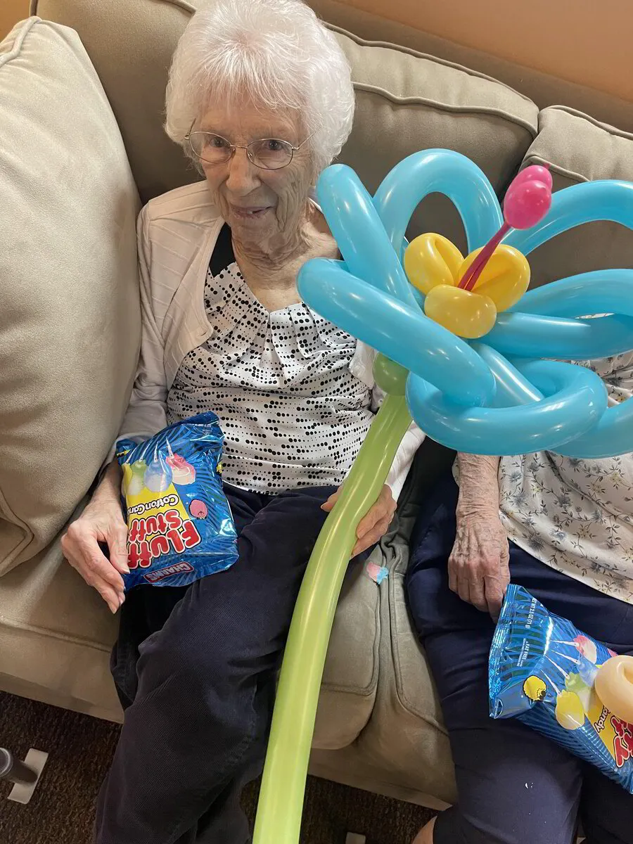 Resident enjoying a balloon flower during an activity