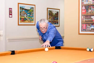 Resident playing pool in a common area