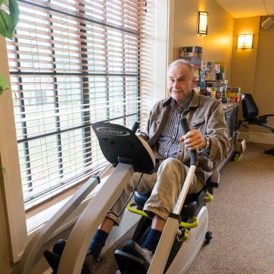 A resident exercising on a recumbent bike in a common area