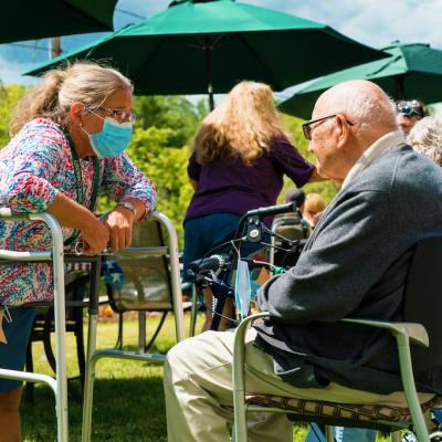 Resident interacting with staff outdoors at the facility
