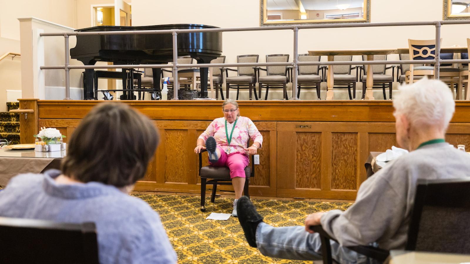 Engaged resident leading a seated activity in a common area