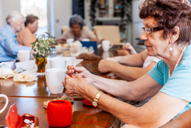 Residents engaging in a crafting activity at a communal table.