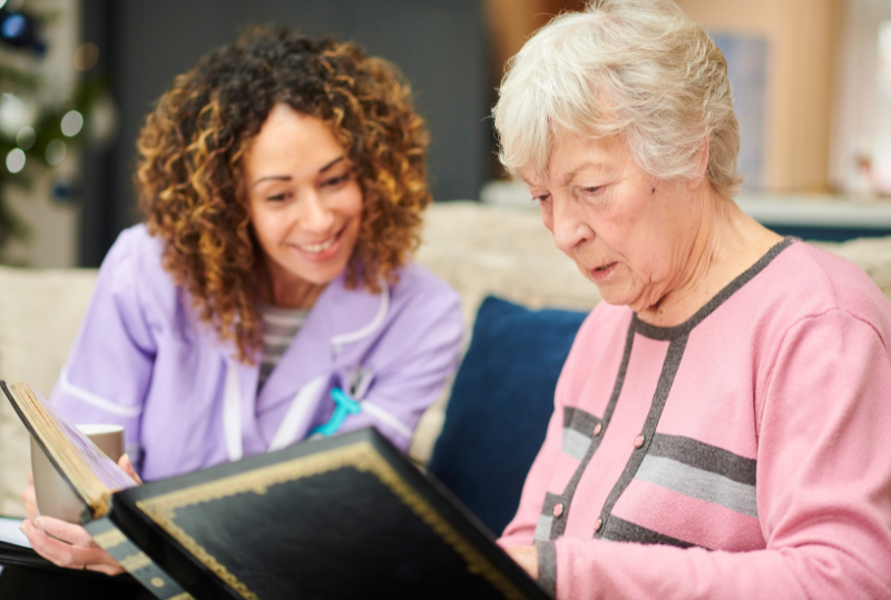 Caregiver assisting a senior resident with a photo album