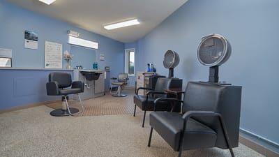 Hair salon area with chairs and hairdryers