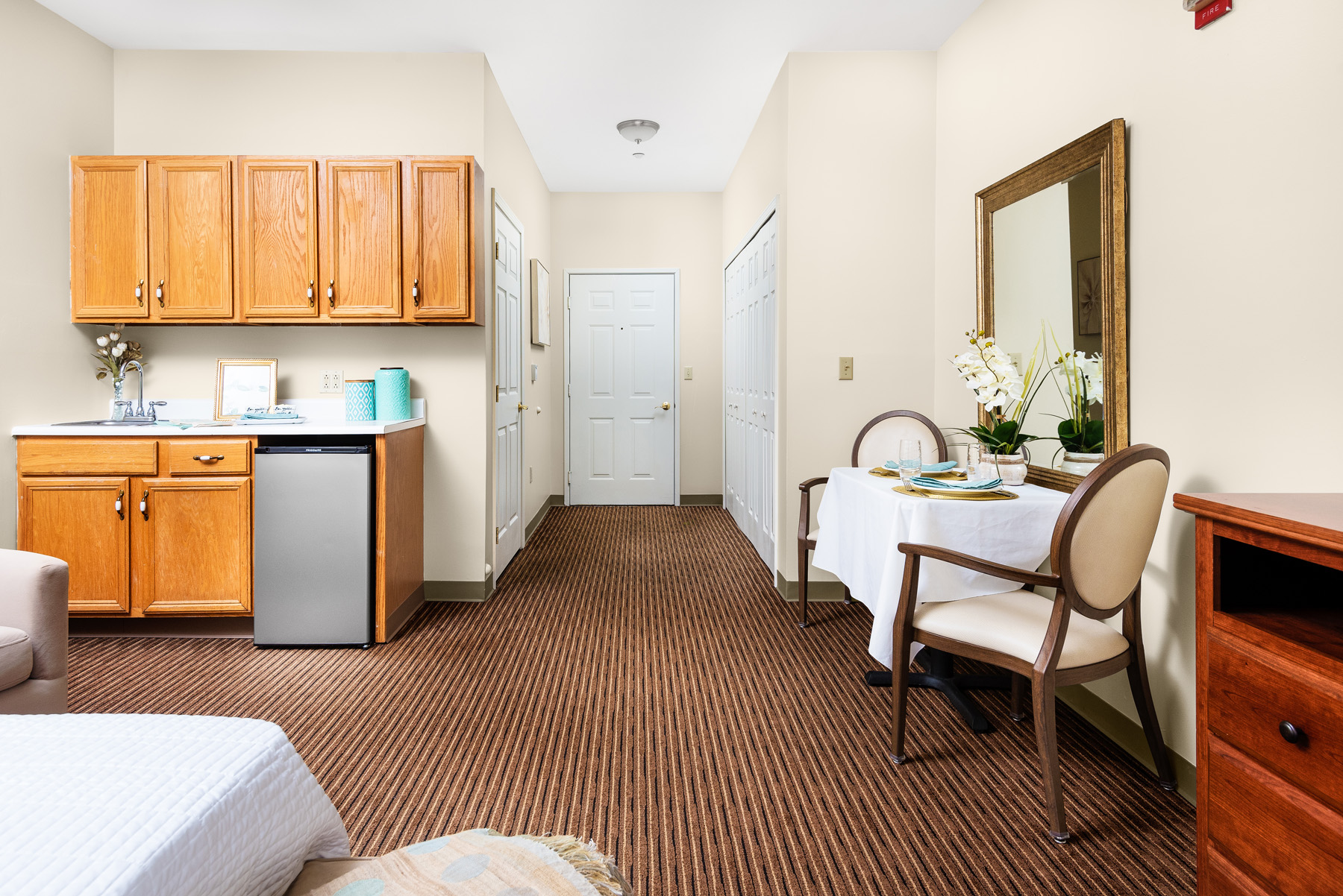 A well-furnished resident room with kitchenette