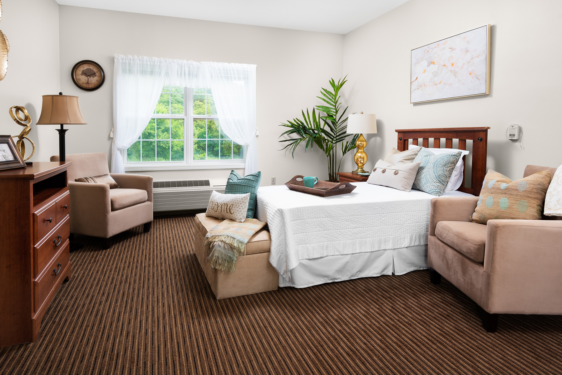 Cozy resident room with a bed, chairs, and decorations