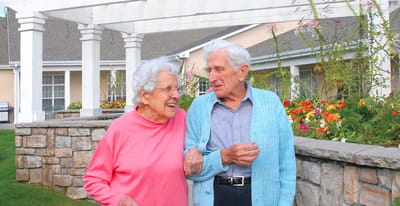 Couple walking together outside in a garden area