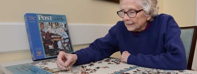 Resident working on a puzzle in an activity area