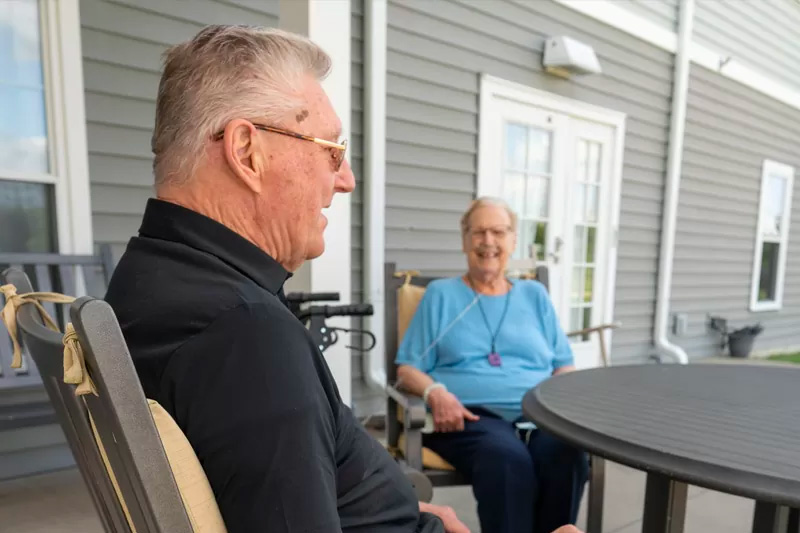 Two residents enjoying time on a patio.