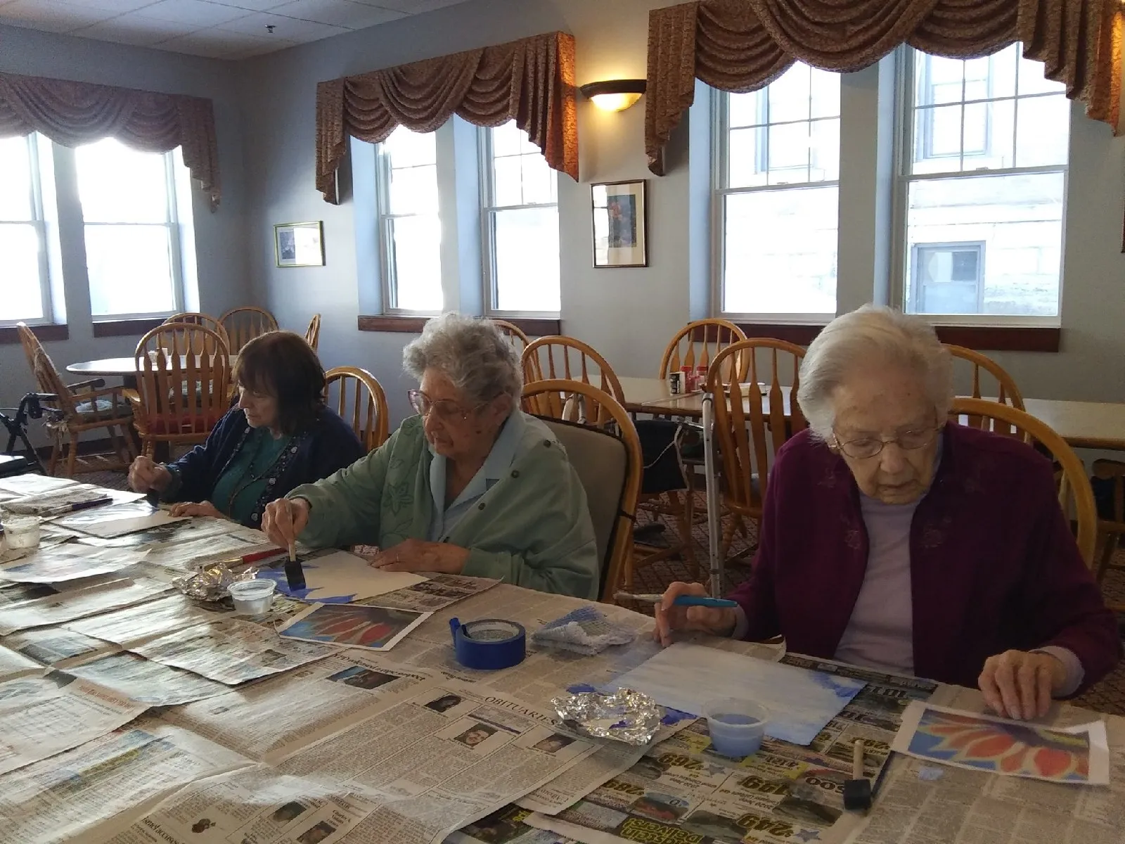 Residents engaged in a creative painting activity indoors
