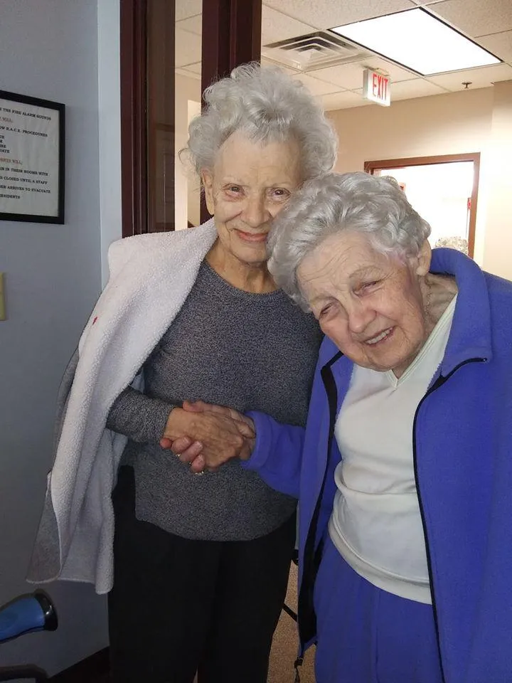 Two elderly women smiling together indoors
