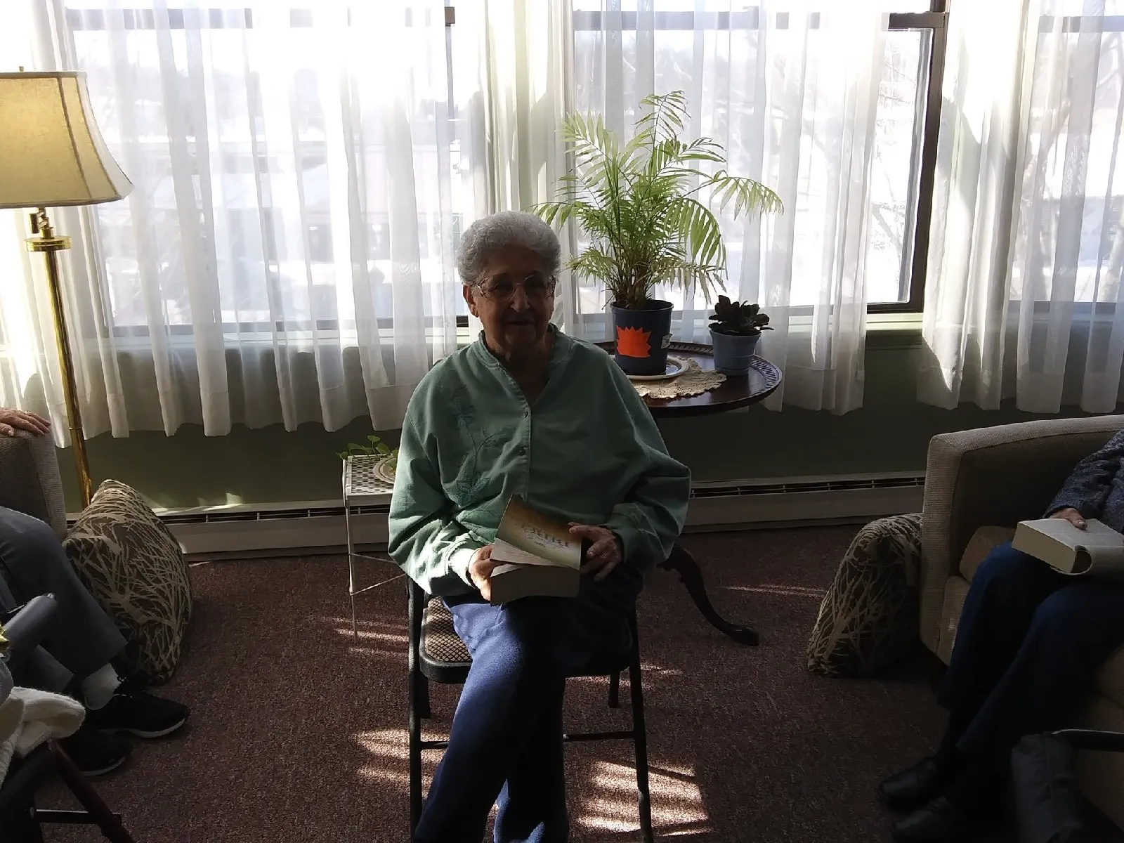 Resident reading a book in a cozy lounge area