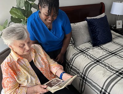 Resident looking at old photos with staff member