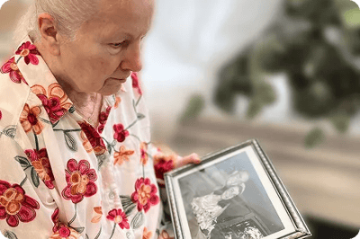 Resident holding a photo frame, reflecting on memories