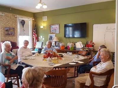 Residents engaging in conversation around a table in a common area