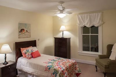 Bright bedroom with floral bedding and a cozy chair