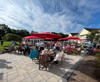 Residents enjoying an outdoor event with shaded seating