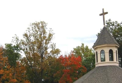 Exterior view of a building with cross and trees