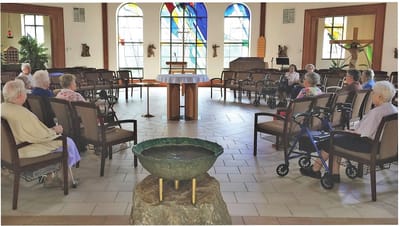 Residents in a common area with stained glass windows