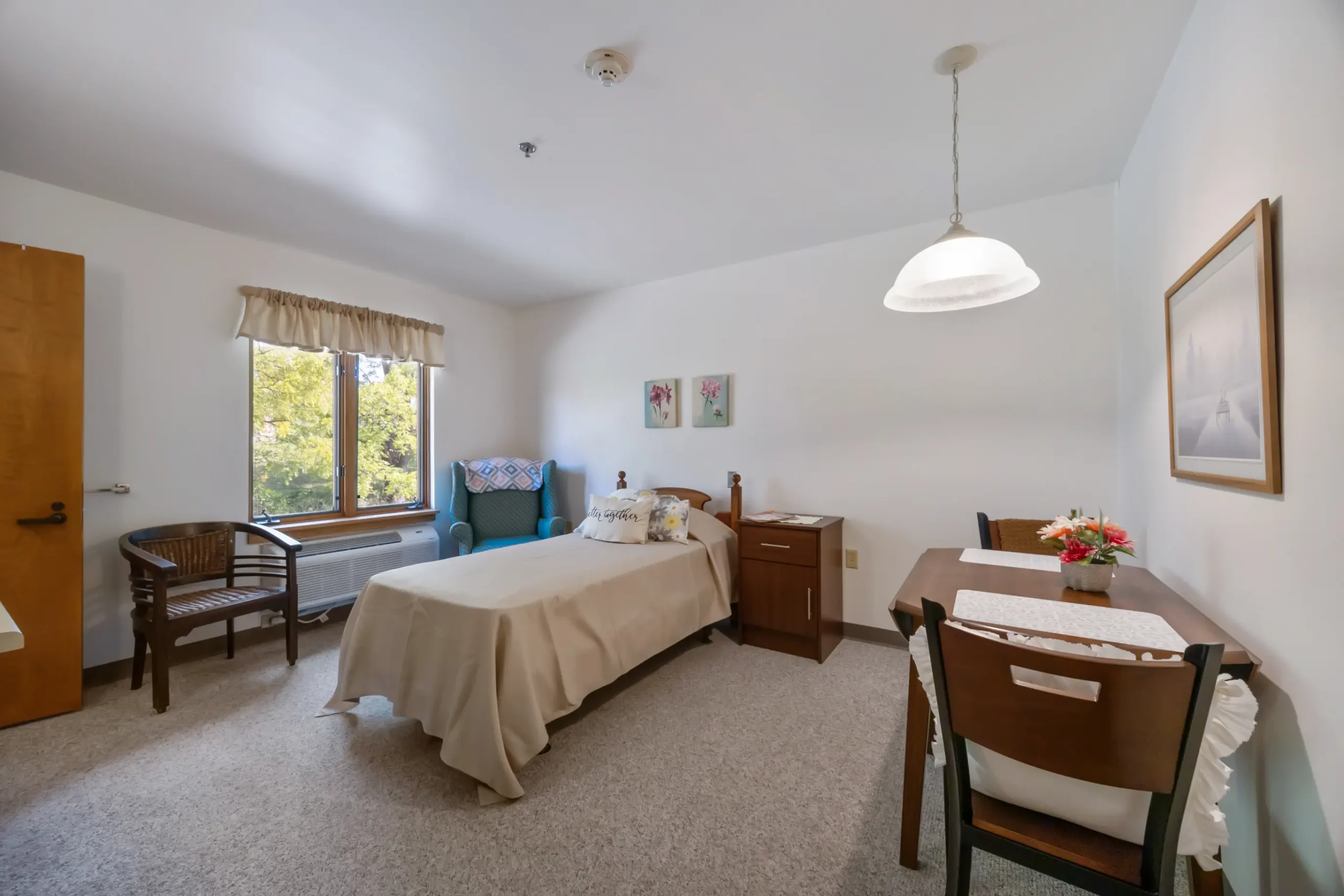 A cozy resident room with a bed and desk