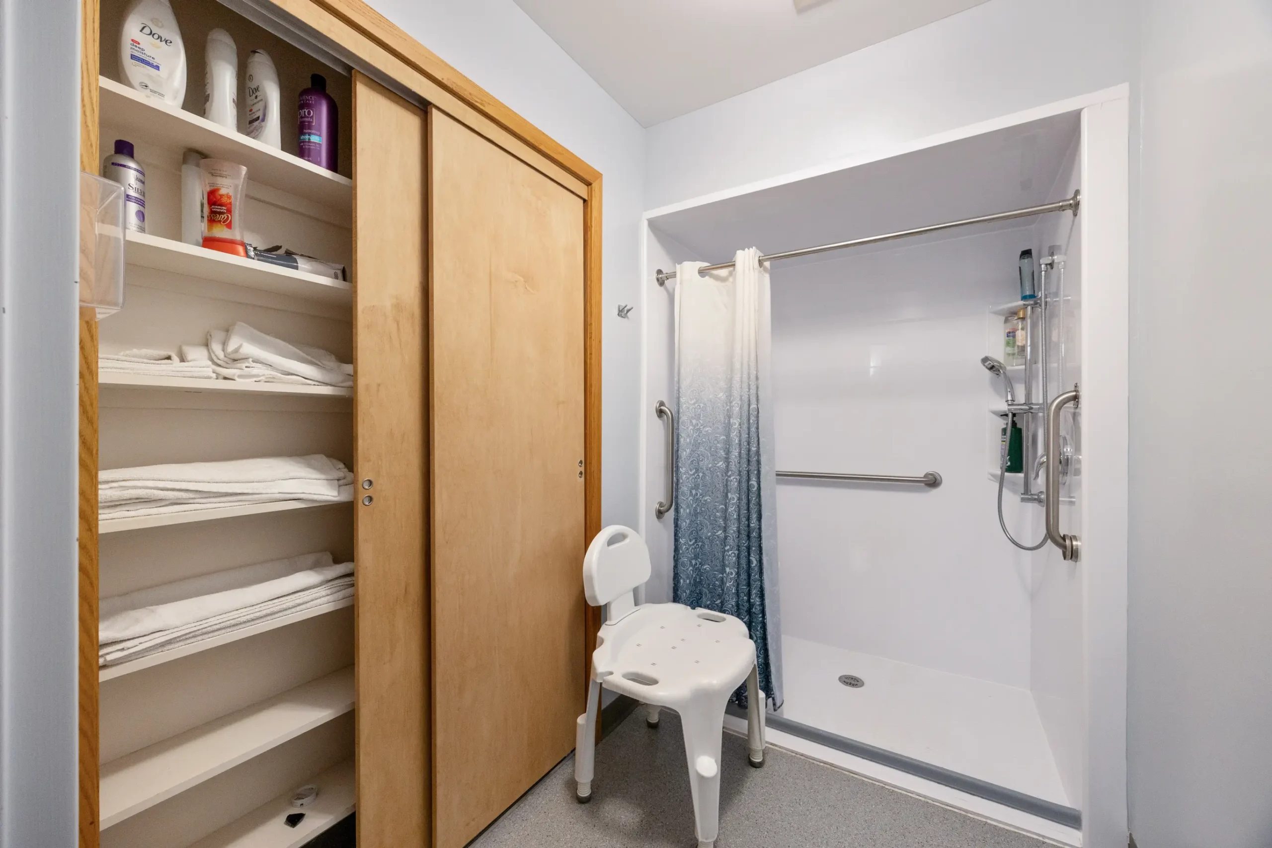 Accessible bathroom with grab bars and shower chair