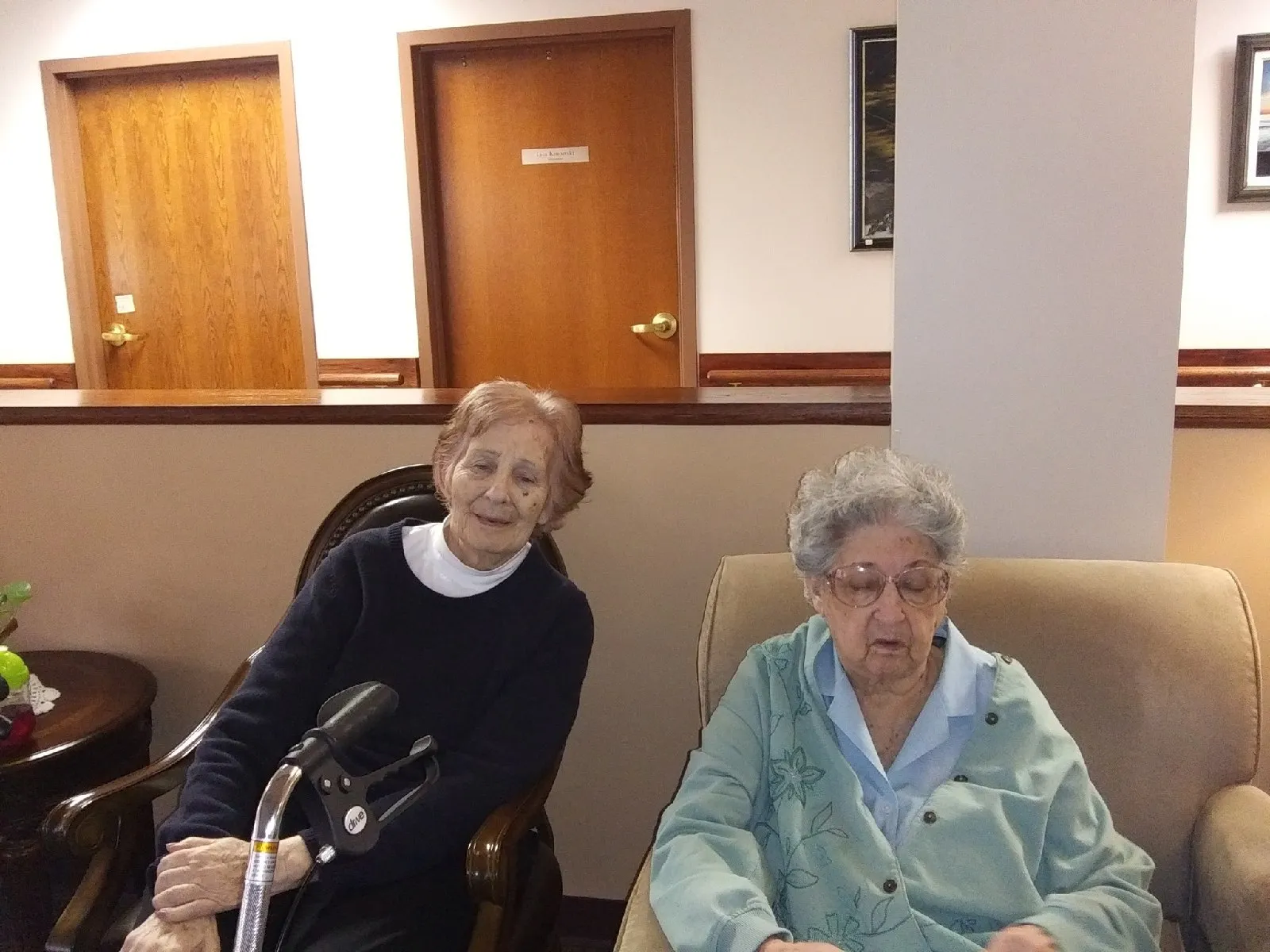 Two residents sitting in a common area inside the facility