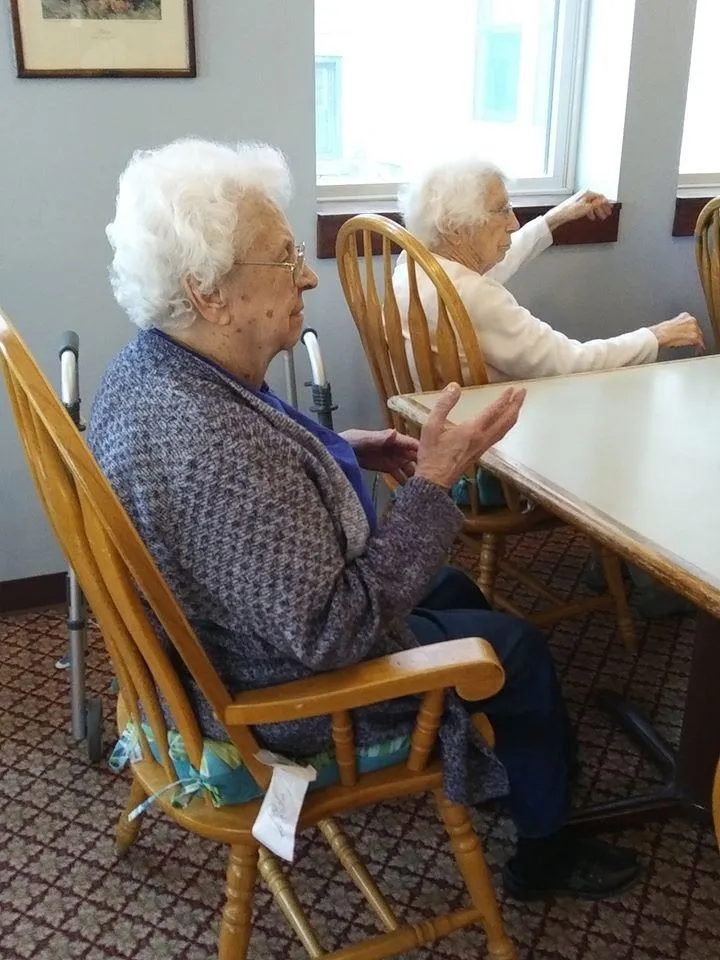 Two elderly women in chairs during an activity