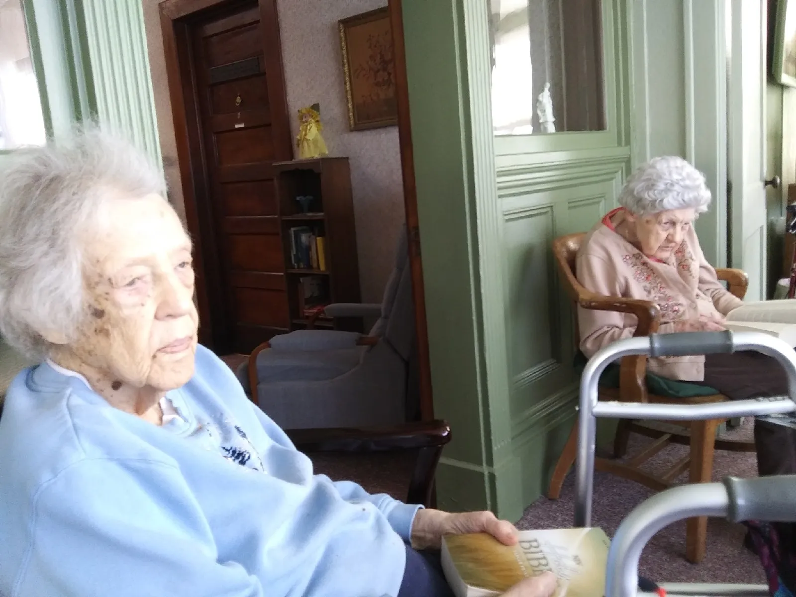 Two elderly women reading in a common area