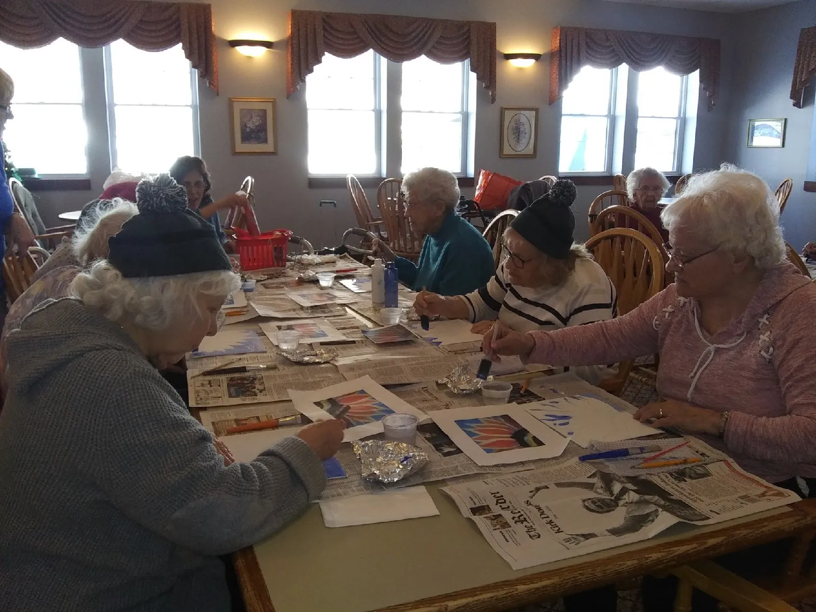 Residents engaged in an art activity at tables