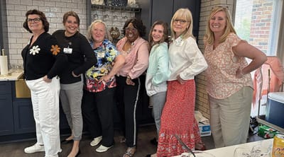 Staff members posing together in a kitchen area