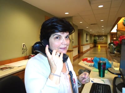 Staff member at reception desk talking on the phone