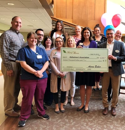 Staff and residents celebrating a donation to Alzheimer's Association