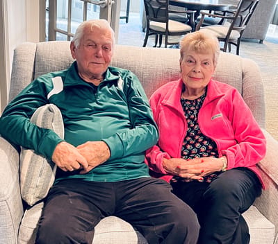 Two residents sitting together in a cozy lounge