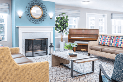 Bright interior common area with seating and a piano