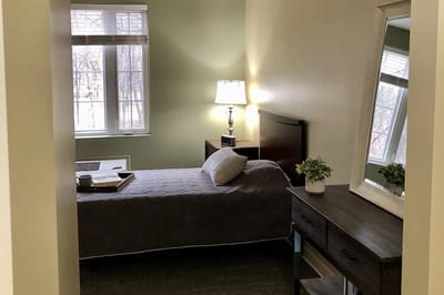 Private resident room with bed and lamp